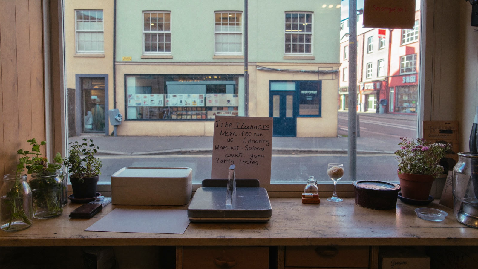 An empty small-shop counter with a street visible through the window, suggesting quiet hiring activity at small businesses.