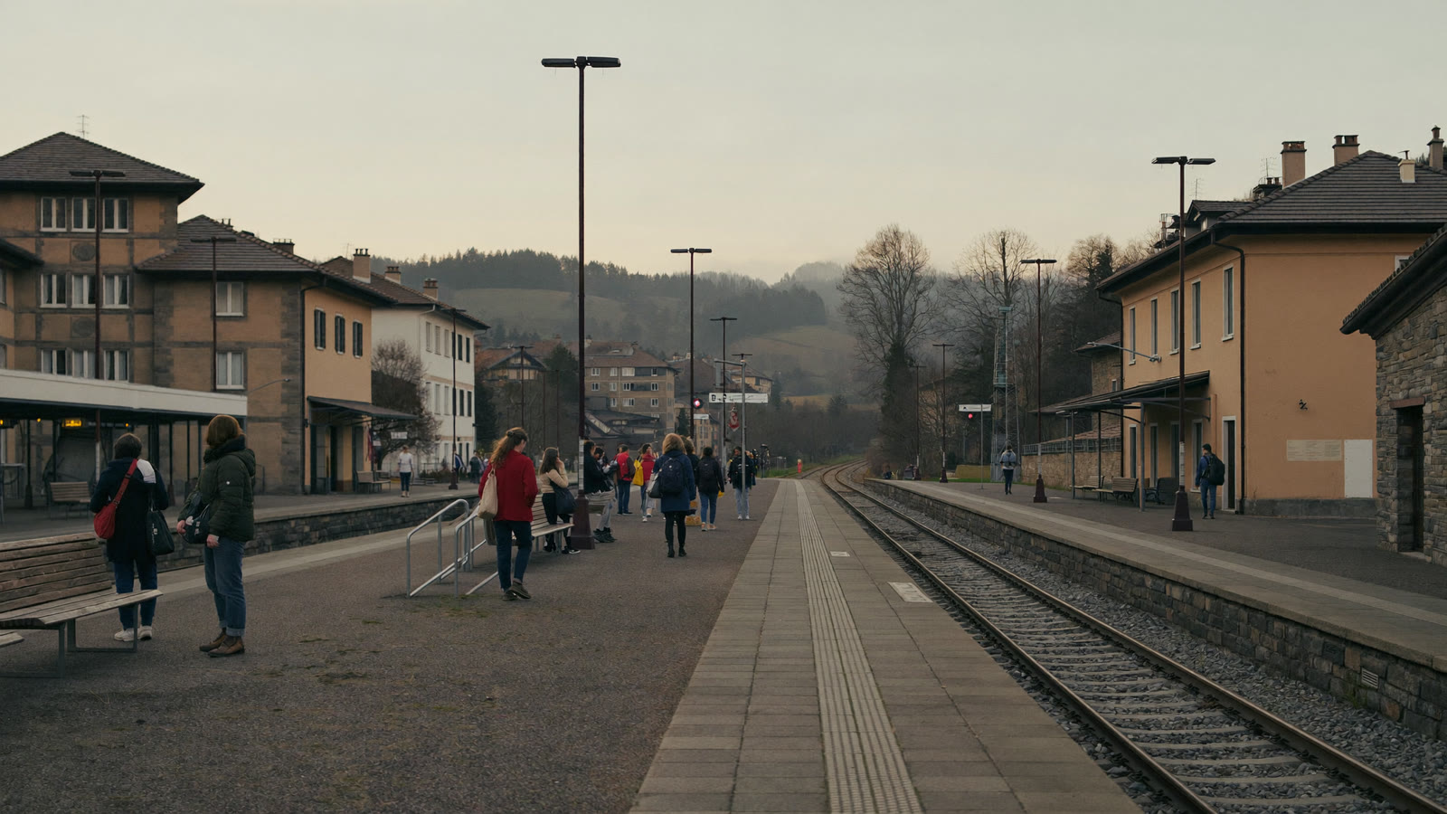 Frontalieri in attesa di un treno per la Svizzera su una banchina al mattino