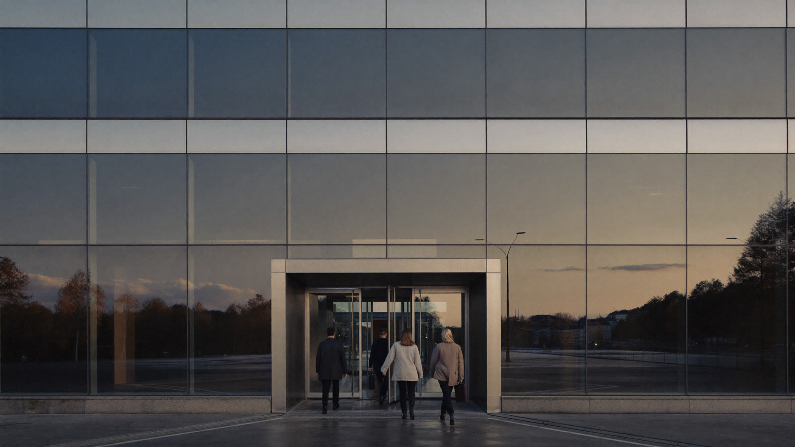Des employés quittent un immeuble de bureaux moderne par un jour d'automne nuageux
